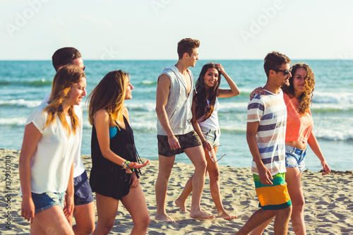 Multiracial group of friends walking on the beach
