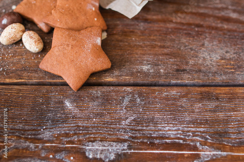 Sweet gingerbread stars on wooden background flat lay. Top view on rustic table with chocolate cookies, free space for advertisement. Menu, dessert, confectionery concept