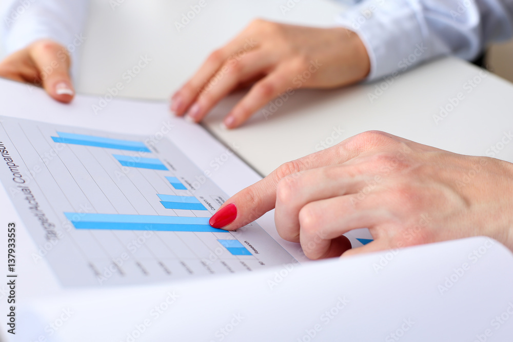 Two businesswomen hold in hands graph Two businesswomen hold in hands graph