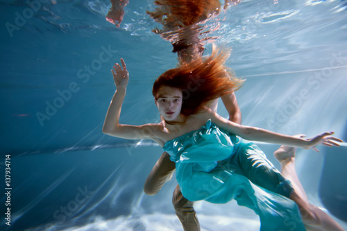 Wallpaper Mural Underwater in the pool with the purest water. Beautiful girl in a scarlet dress and flowing hair. Torontodigital.ca