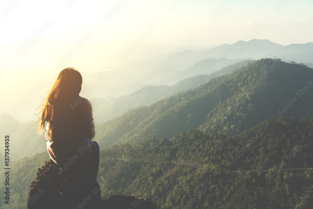 silhouette woman sitting on mountain in morning and vintage filter