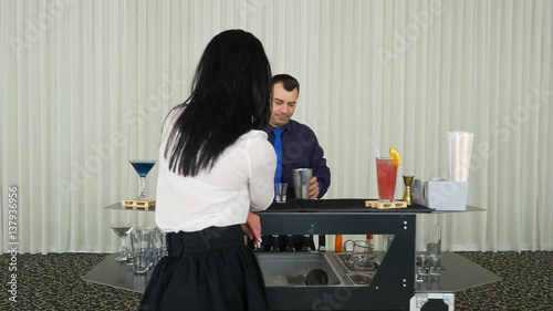 Bartender mixing cocktail shots drinks for woman waiting at private event photo