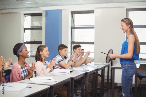 Students appreciating classmate after presentation in classroom