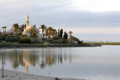 Architecture of Hala Sultan Tekken with water reflections and cloudy sky