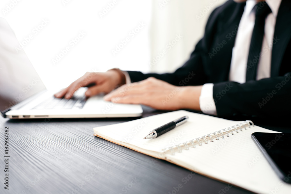 Side view shot of a man's hands using smart phone in interior, rear view of business man hands busy using cell phone at office desk, young male student typing on phone sitting at wooden table, flare Side view shot of a man's hands using smart phone in interior, rear view of business man hands busy using cell phone at office desk, young male student typing on phone sitting at wooden table, flare