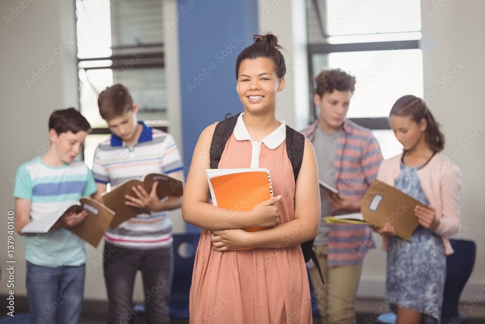 Schoolgirl holding notebook in classroom Schoolgirl holding notebook in classroom