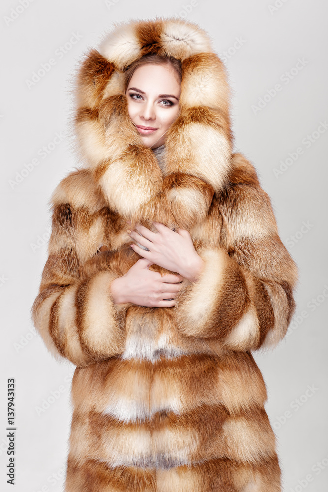 portrait of beautiful young blonde woman in luxury Fox fur coat.