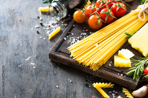 Raw pasta spaghetti and cooking ingredients. Italian food background