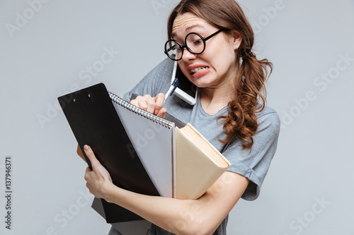 Shocked Clumsy female nerd talking on phone photo