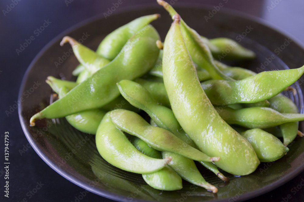 boiled green soybeans on black dish boiled green soybeans on black dish