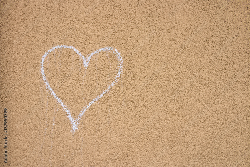 Heart drawn by chalk on the light brown wall. Picture is taken in Bergamo, Italy on February 24, 2017.