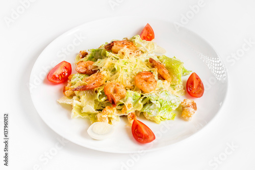 Plate of caesar salad with shrimps isolated at white background.