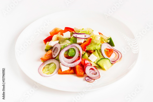 Plate of fresh vegetable salad at white isolated background.