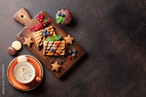 Coffee, sweets and waffles with berries