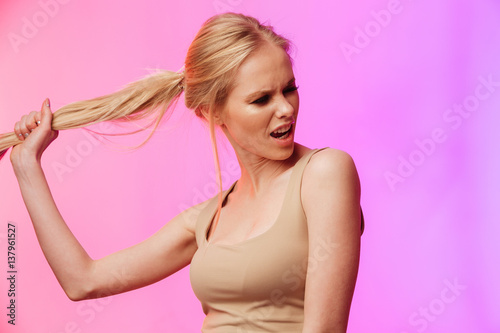 Gorgeous woman standing and posing over pink background.