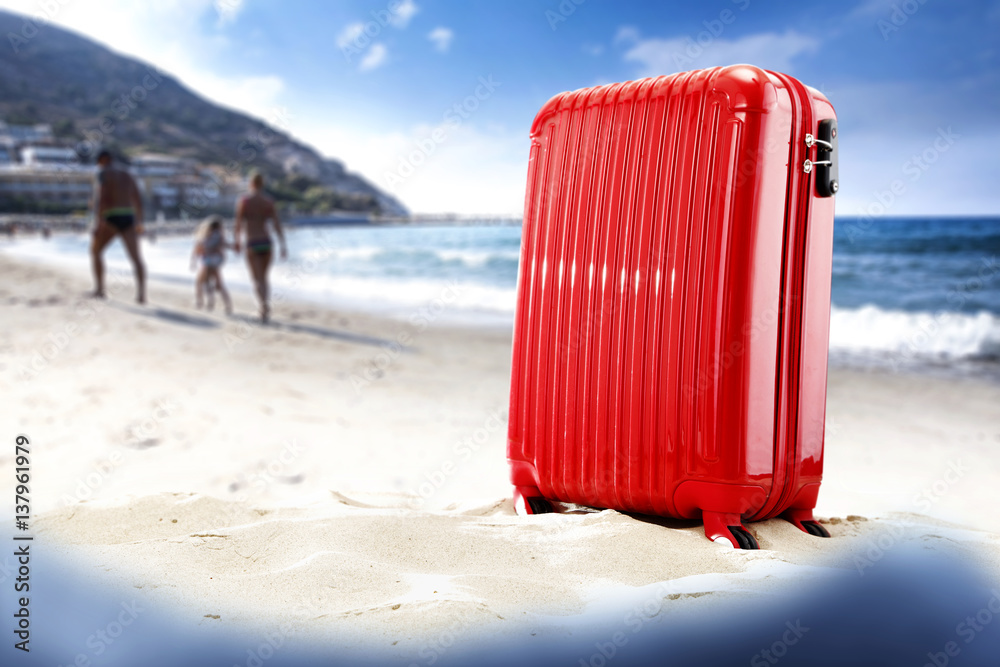 summer time and suitcase on sand 