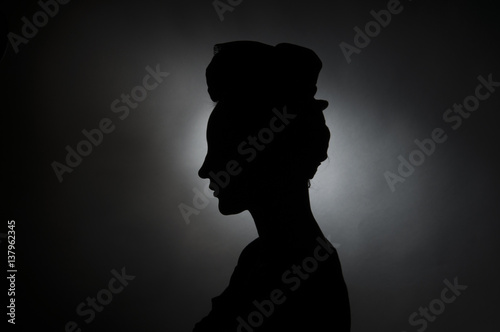 Female silhouette. Black-and-white photo in the studio on a black background.
