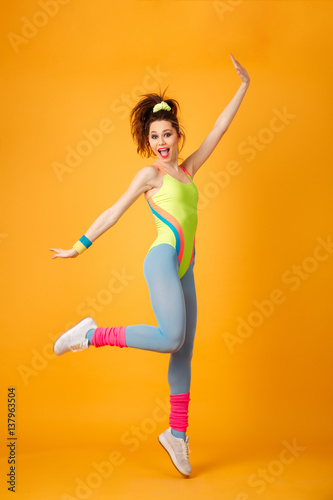 Happy excited young fitness woman jumping and having fun