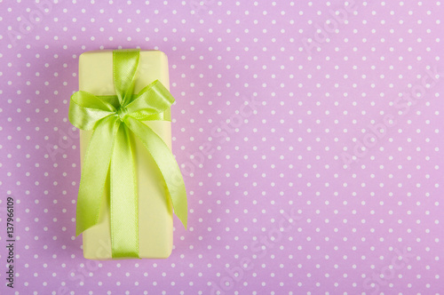 Gift box with a bow on a background of polka dots. Copy space