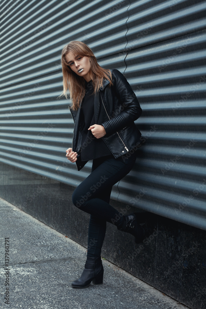Portrait of fashionable blonde european girl wearing black leather jacket,  black jeans. Posing on dark metal background. Trendy, Urban street style.  Autumn Vogue Style. Toned instagram filters Stock 写真 | Adobe Stock