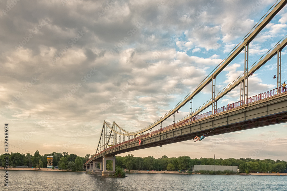 Pedestrian bridge over the river at sunset Pedestrian bridge over the river at sunset