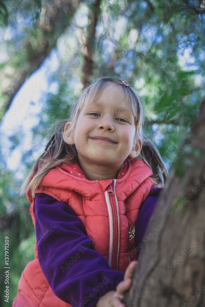 Little pretty girl with blue eyes in a red vest in the park Little pretty girl with blue eyes in a red vest in the park