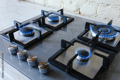 Cooktop with burning gas ring. Gas cooker with blue flames.