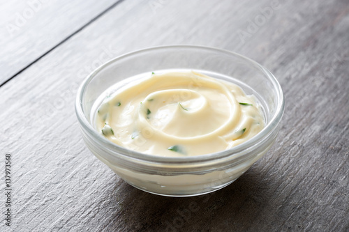 Aioli sauce in bowl on wooden background 
