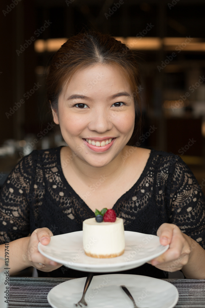 Woman Holding Salted Caramel Cheesecake Decorated with Berries Woman Holding Salted Caramel Cheesecake Decorated with Berries