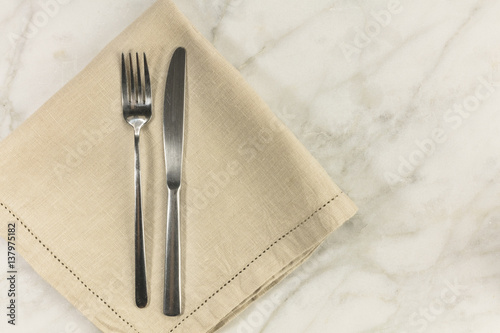 Retro fork and knife on white marble table with copyspace