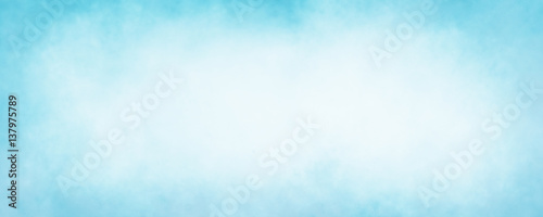 pastel sky blue background with soft puffy cloudy white center with faded vintage textured border photo