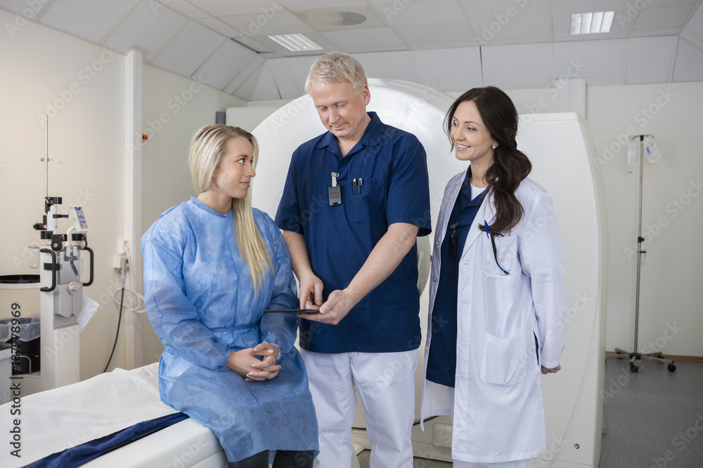 Obraz premium Professional With Colleague And Patient Using Computer Before MR