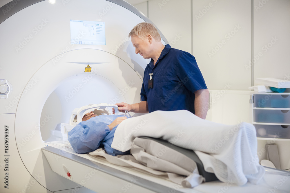 Doctor Putting Coil On Patient's Head Undergoing MRI Scan Doctor Putting Coil On Patient's Head Undergoing MRI Scan