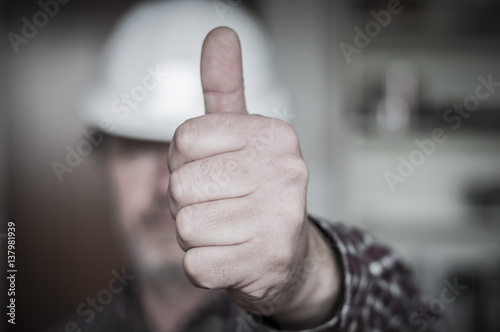 Bauarbeiter zeigt Hand mit Daumen nach oben / Positive Emotion, Bauarbeiter zeigt Hand mit Daumen hoch, geringe Tiefenschaerfe. photo