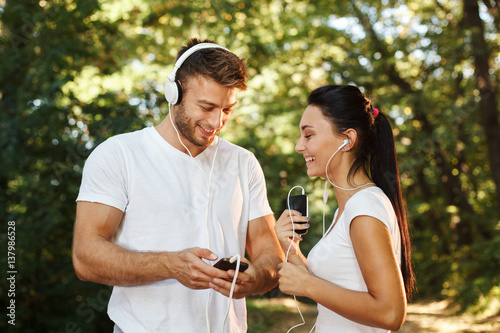 Young couple enjoying the music before jogging in the park © djile