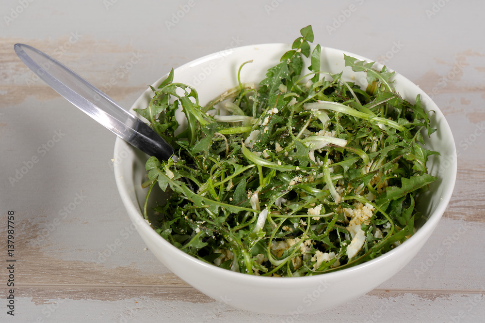 Fresh dandelion leaves in a bowl close up Fresh dandelion leaves in a bowl close up