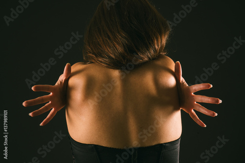 espalda de una mujer latina con las manos en los homoplatos