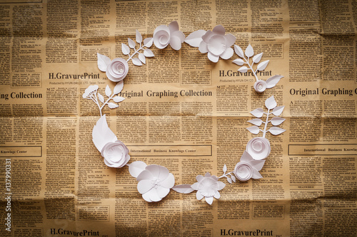 vintage frame with paper flowers on the old newspapper photo