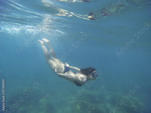 turquoise sea with a young woman scuba diving with a snorkel isolated under the sea © beavera