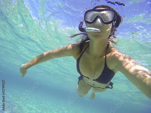 woman with snorkel scuba diving isolated under a turquoise sea.