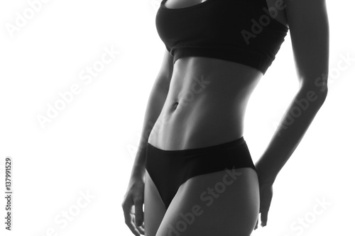 Sexy slim fit woman body abs. Muscled abdomen. Sportswear. Isolated on white. Black and white image