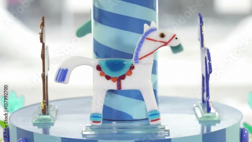 Closeup of small glass carousel in the shop window