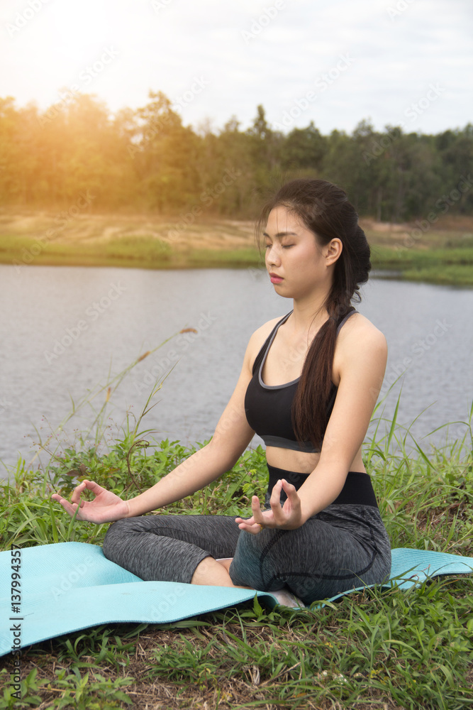 Young women pose yoga on nature background