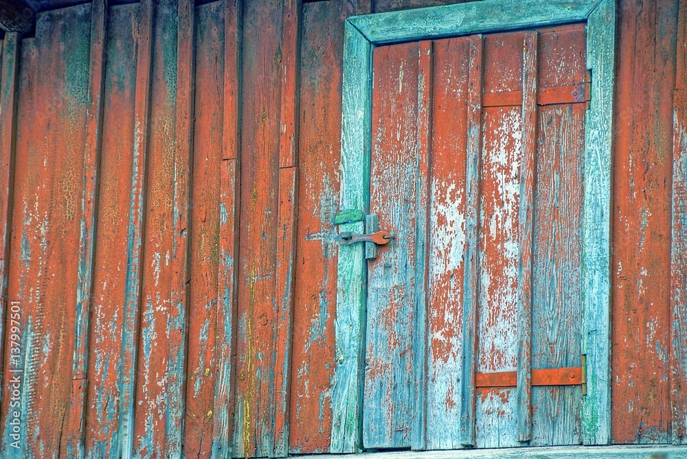 Старая дверь на красной деревянной стене