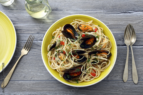 pasta italiana spaghetti con le cozze sfondo tavolo di cucina grigio photo