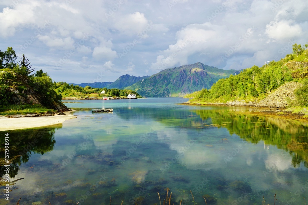Fototapeta premium Mountains reflecting over clear turquoise water in the Lofoten Islands, Norway
