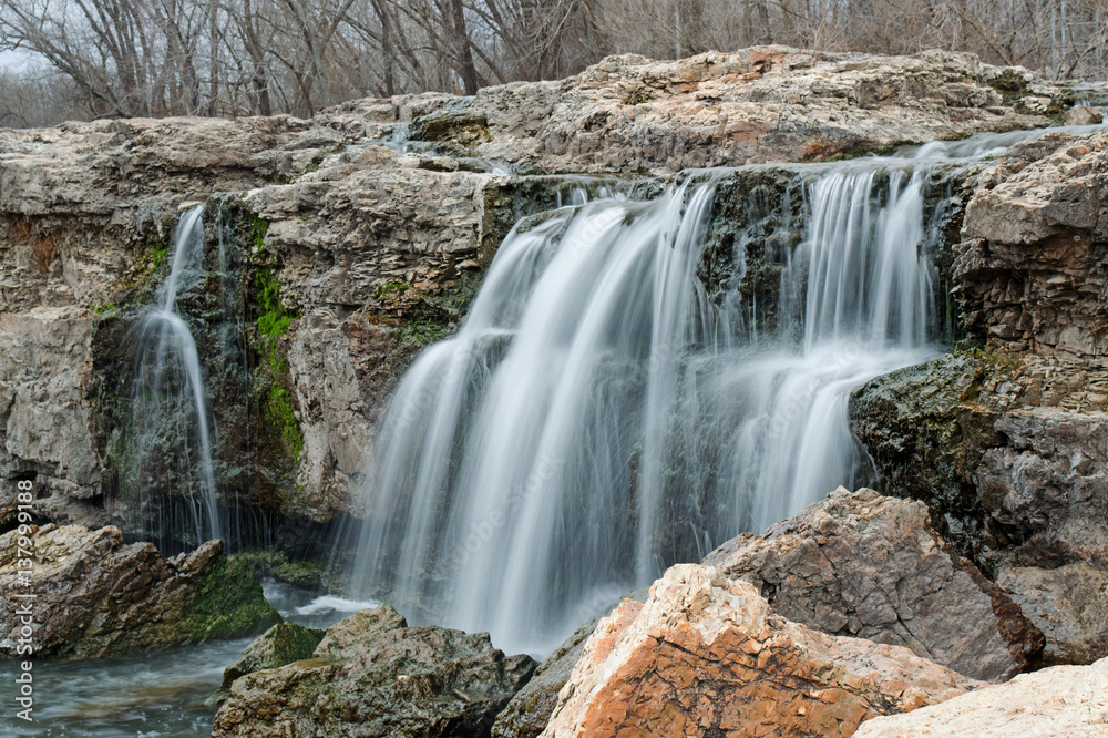 Waterfall among boulders on a warm winter day makes a scenic view