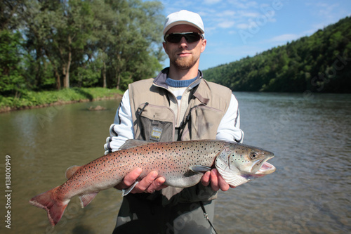Danube salmon/ Fisherman presenting huchen. Spin fishing in San River, Sub-Carpathian region. The huchen is endemic to the Danube basin in Europe and also occurs in Dunajec River.