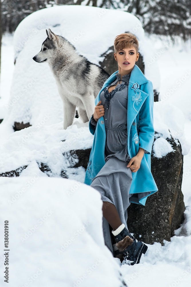 fashionable and stylish woman in winter park with dog husky