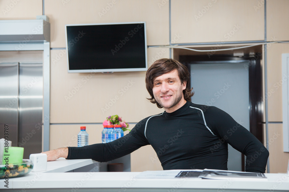Handsome man in sports outfit on reception of fitness club Handsome man in sports outfit on reception of fitness club